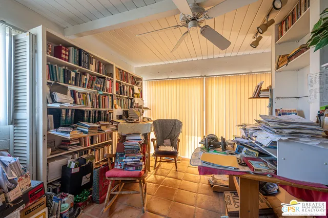 a view of a workspace with furniture and a window