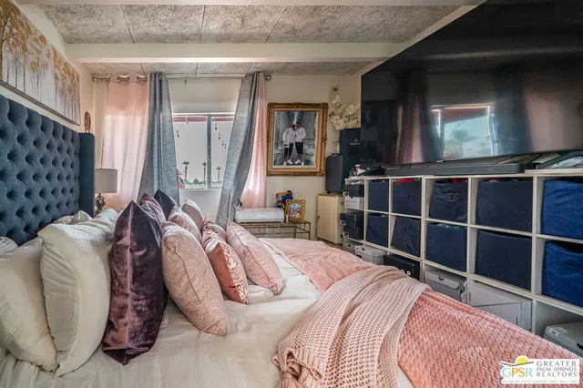 a bedroom with a bed and a flat screen tv