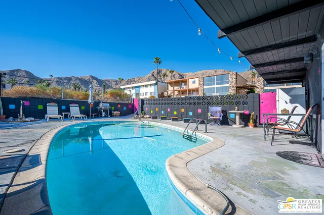 a swimming pool with outdoor seating and yard