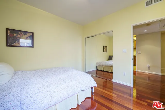 a bedroom with a bed and wooden floor