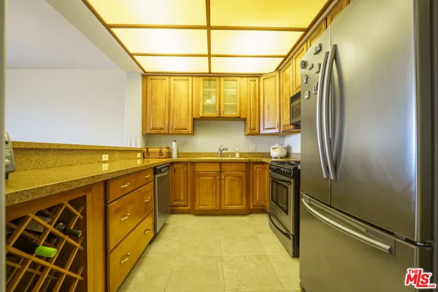 a kitchen with stainless steel appliances a sink cabinets and a window