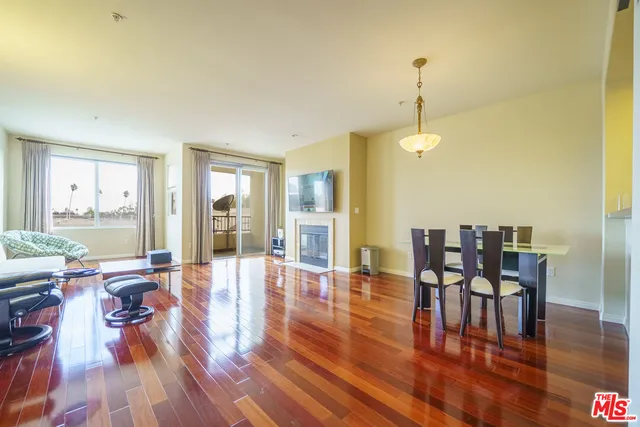 a dining room with wooden floor a chandelier a glass table and chairs