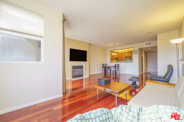 a living room with furniture a flat screen tv and kitchen view