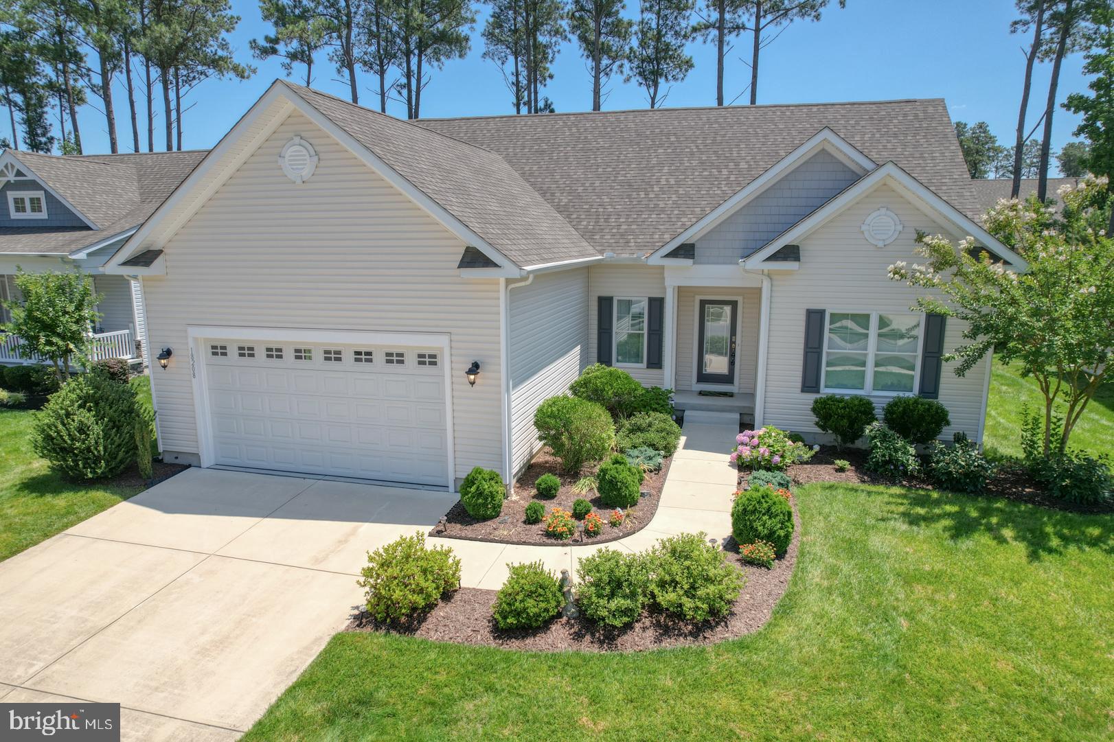 a view of a white house with a yard and plants