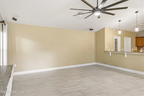 an empty room with a ceiling fan and a window