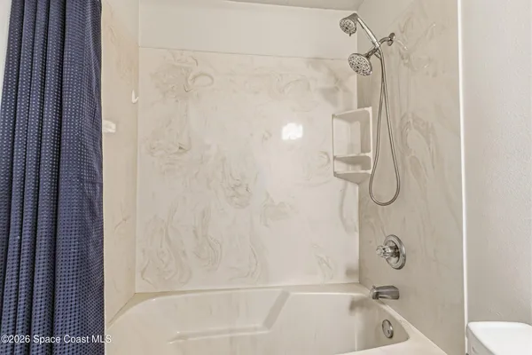 a bathroom with a bath tub with a shower