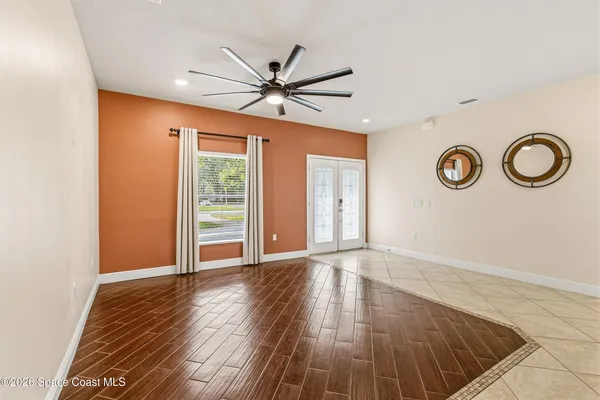a view of an empty room with wooden floor and window