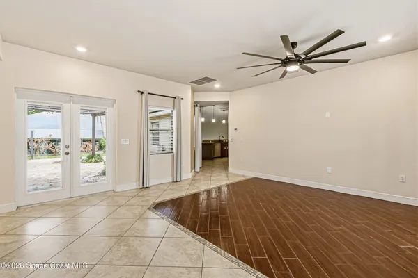 a view of a livingroom with a chandelier fan and wooden floor