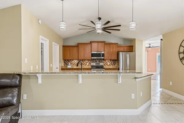 a view of a kitchen with center island and stainless steel appliances