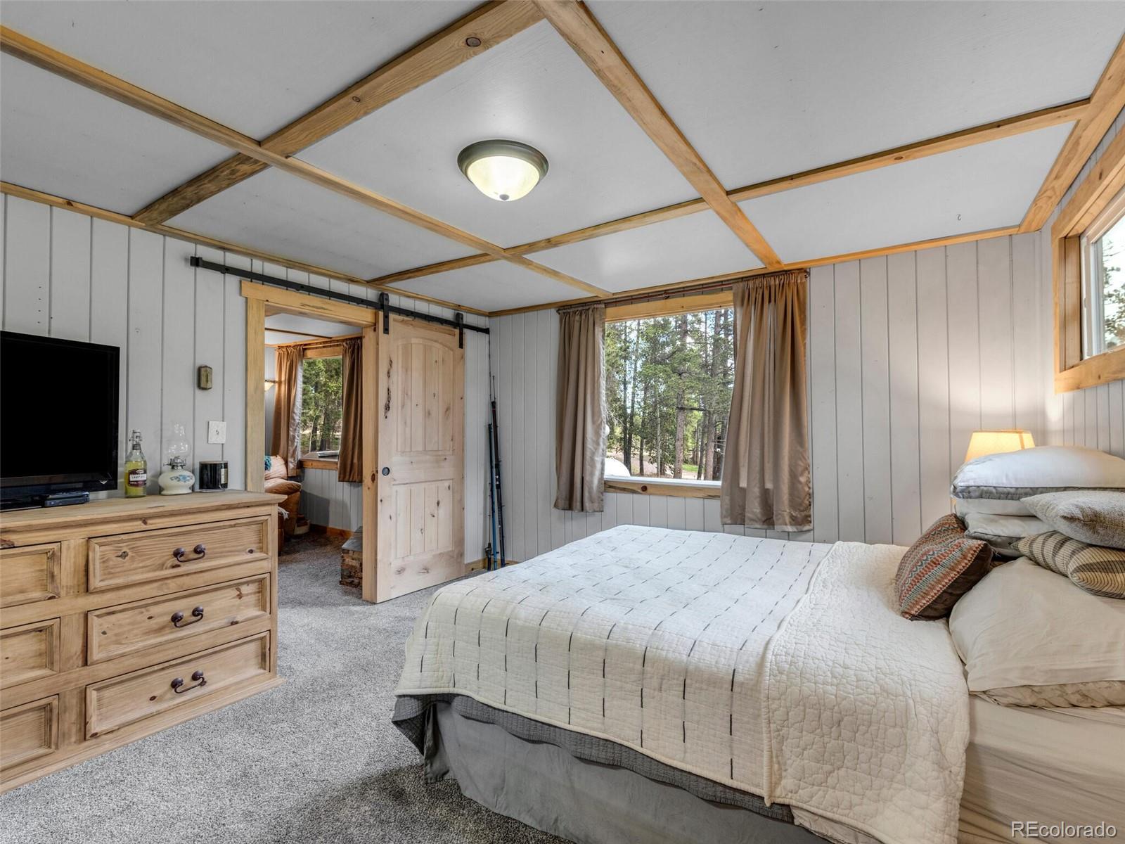 146 Dynamite Drive Black Hawk, CO 80422 - Photo 18 of 26 a bedroom with a large bed and flat tv screen on dresser