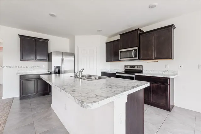 a kitchen with stainless steel appliances granite countertop a sink stove microwave and cabinets