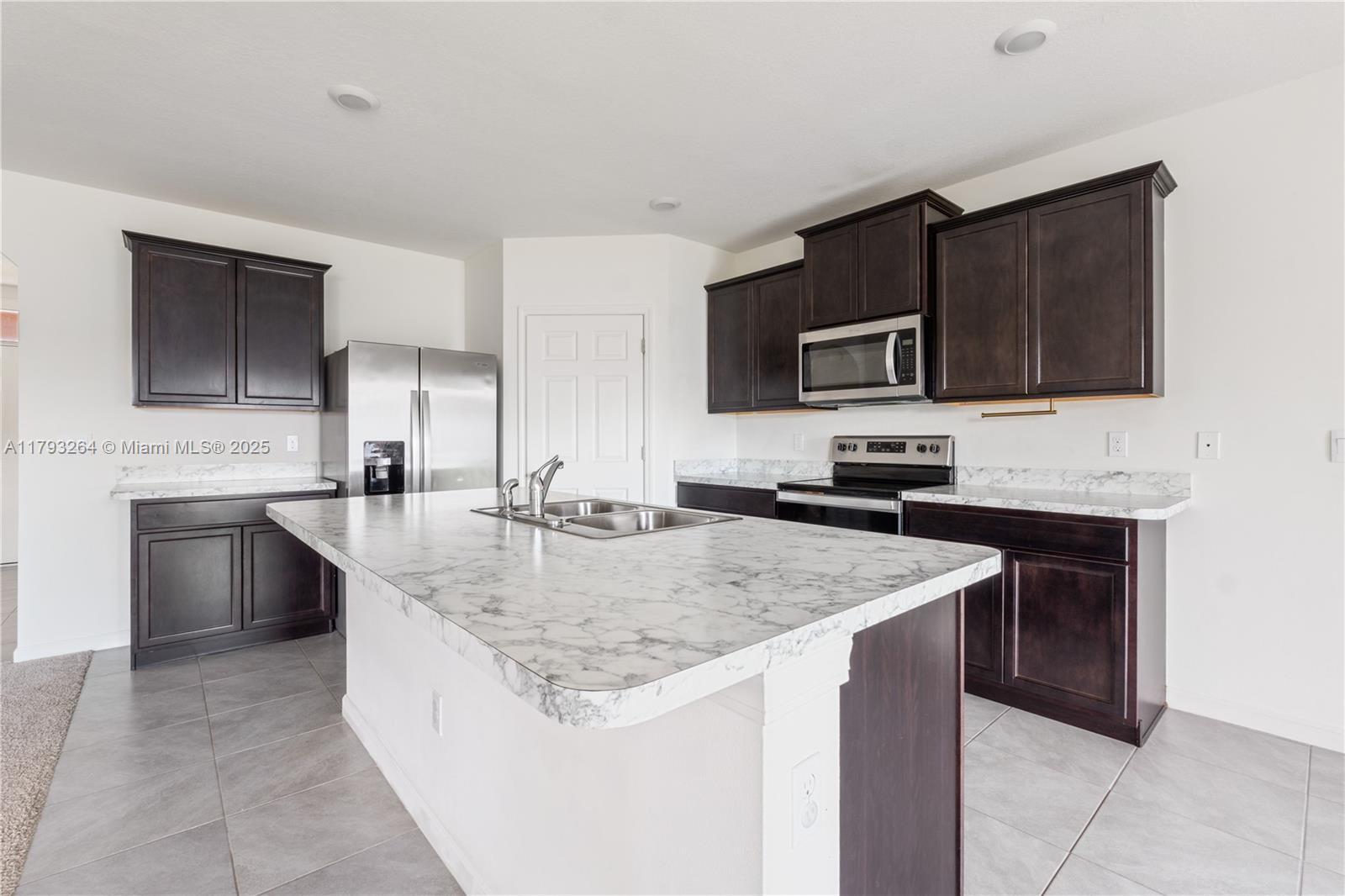 5305 Fantasy Drive Fort Pierce, FL 34947 - Photo 5 of 14 a kitchen with stainless steel appliances granite countertop a sink stove microwave and cabinets
