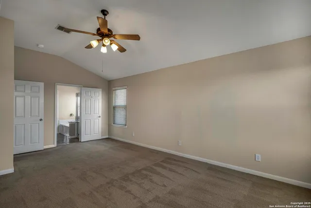 a view of an empty room with a chandelier fan