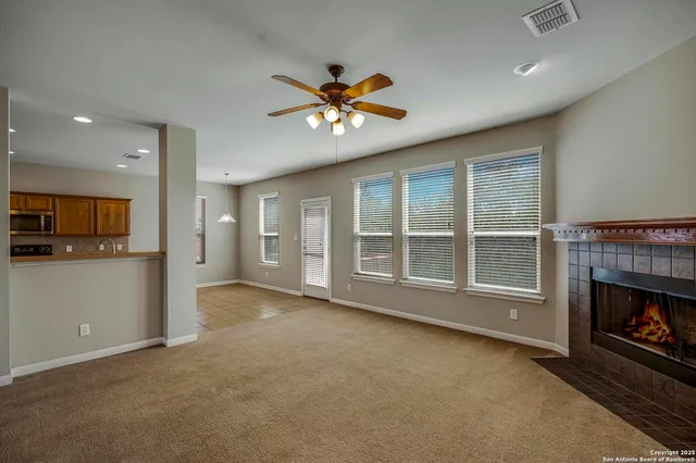 a view of an empty room with a fireplace and a window