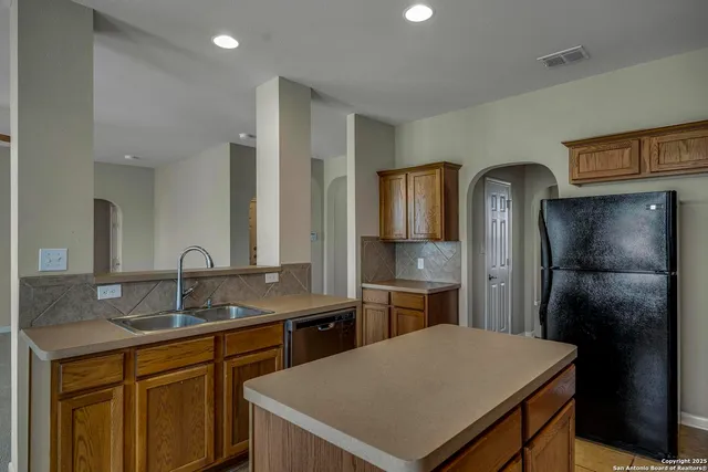 a kitchen with a sink refrigerator and cabinets
