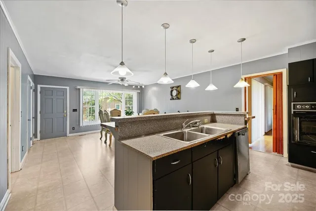 a kitchen with stainless steel appliances granite countertop a sink a counter space and a refrigerator