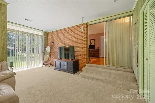 a spacious bedroom with a bed a couch and a chandelier