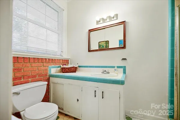 a bathroom with a toilet sink and mirror