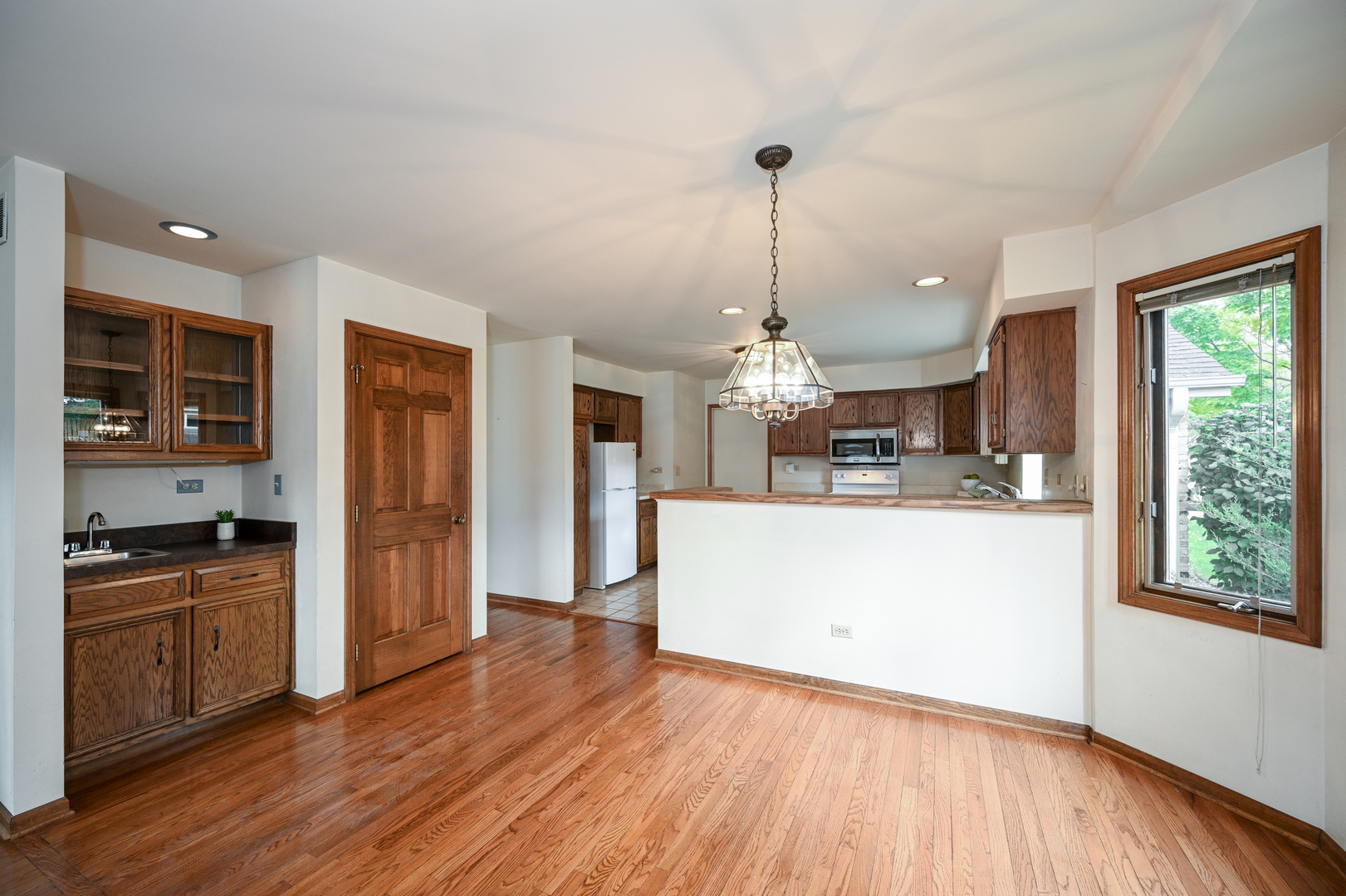 520 Renn Court Wheaton, IL 60187 - Photo 14 of 33 a kitchen with stainless steel appliances granite countertop wooden floors and white cabinets
