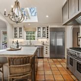 a kitchen with stainless steel appliances granite countertop a stove a refrigerator a sink and a dining table