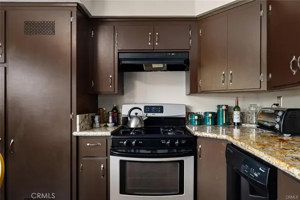 a kitchen with stainless steel appliances granite countertop a stove a sink and a microwave