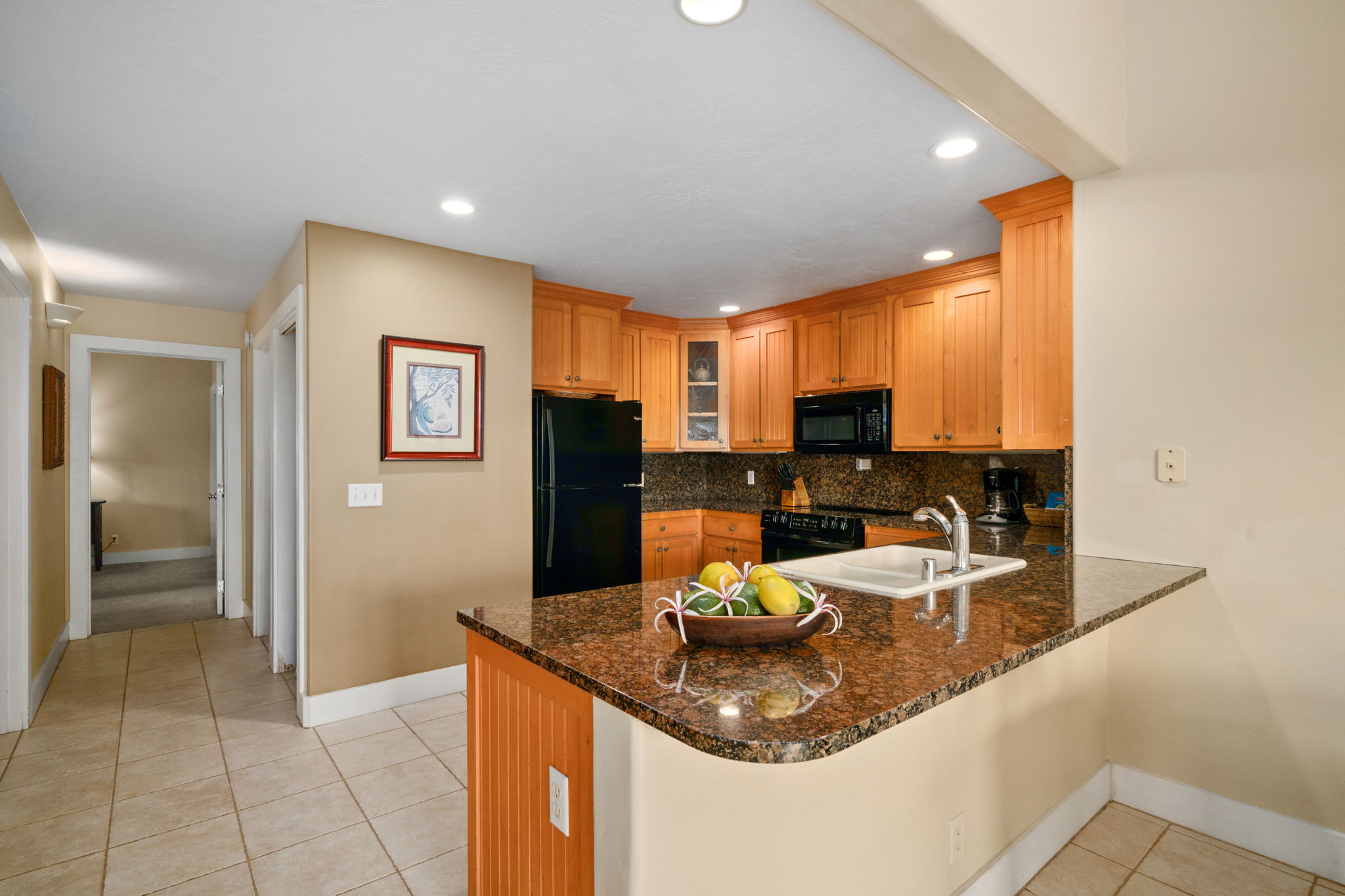 1831 Poipu Road, Unit 823 Koloa, HI 96756 - Photo 8 of 30 a kitchen with a sink a refrigerator and cabinets