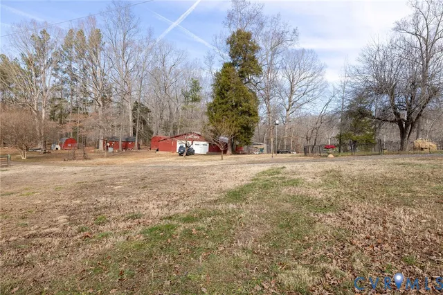 a view of a tiny house with a yard and wooden fence