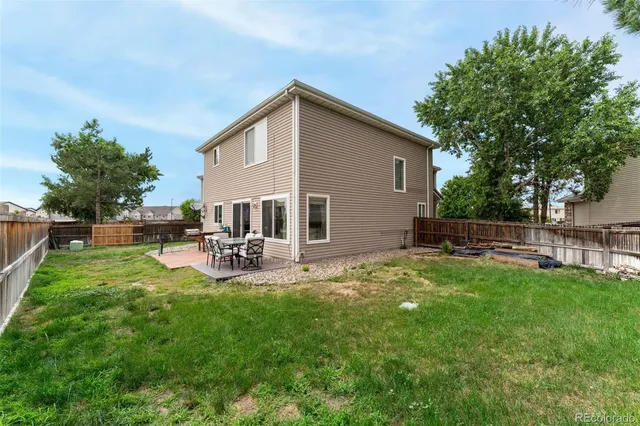 a view of backyard of house with outdoor seating and green space