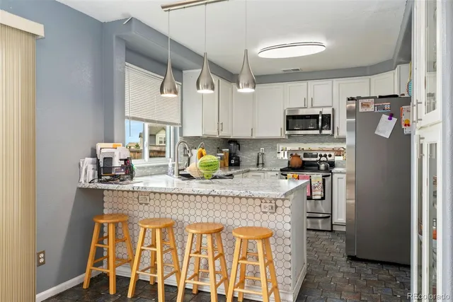a kitchen with stainless steel appliances granite countertop a refrigerator and a stove top oven