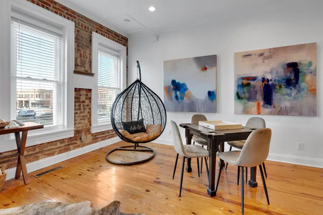 a view of livingroom and dining room with furniture wooden floor and windows