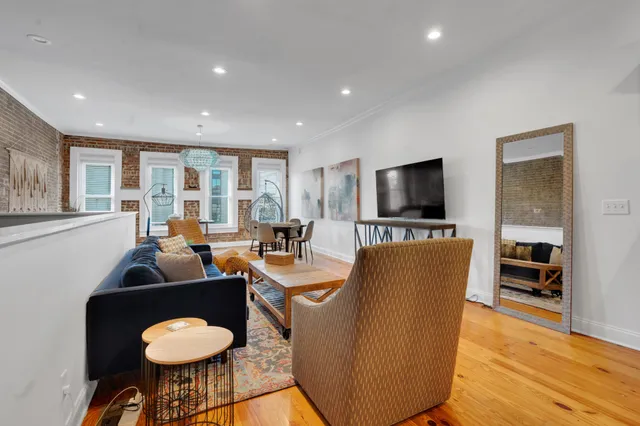 a living room with furniture a flat screen tv and a large window