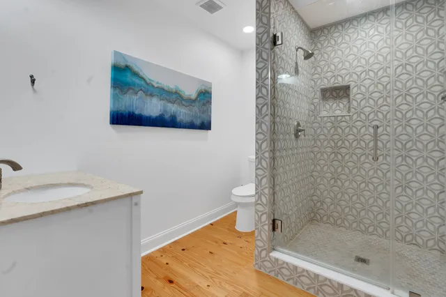 a bathroom with a granite countertop sink a toilet and shower