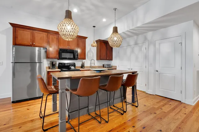 a kitchen with a table chairs refrigerator and cabinets