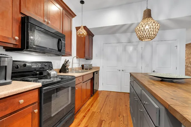 a kitchen with granite countertop a sink a stove and wooden cabinets