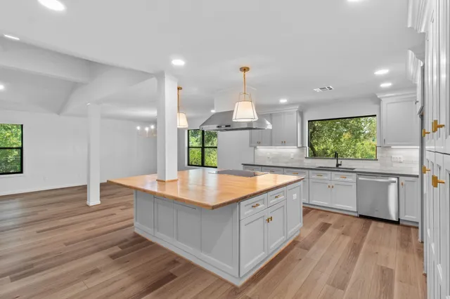a large kitchen with kitchen island white cabinets and wooden floor