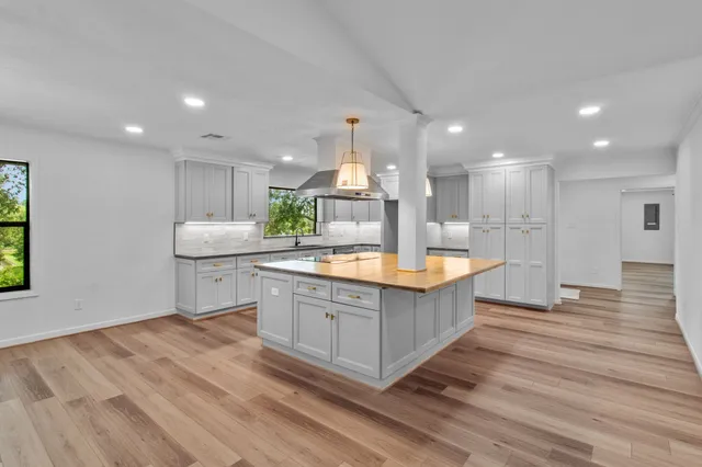 a large kitchen with kitchen island a sink stainless steel appliances and cabinets