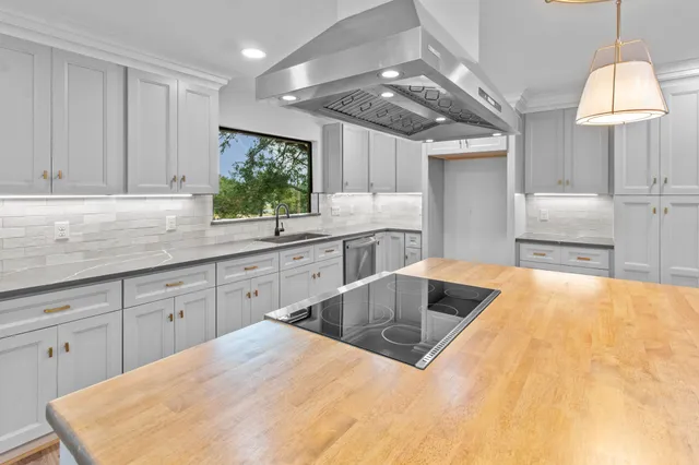a kitchen with kitchen island granite countertop a sink window and cabinets