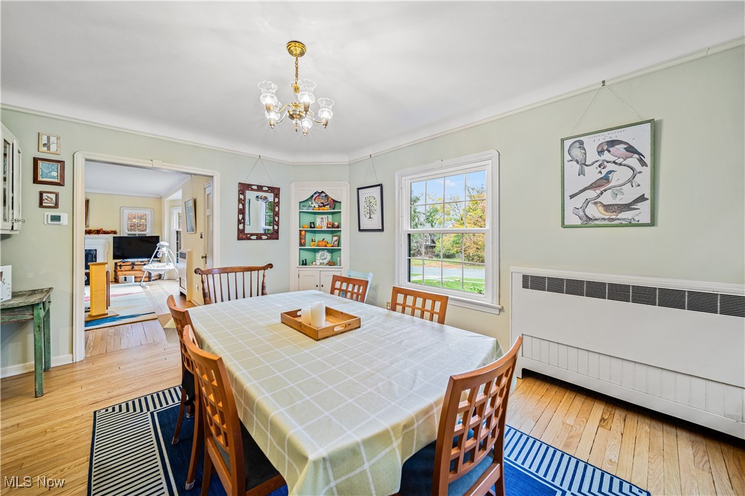 2710 Edgehill Road Cleveland, OH 44106 - Photo 11 of 44 Dining room featuring radiator, light hardwood / wood-style floors, a notable chandelier, and crown molding