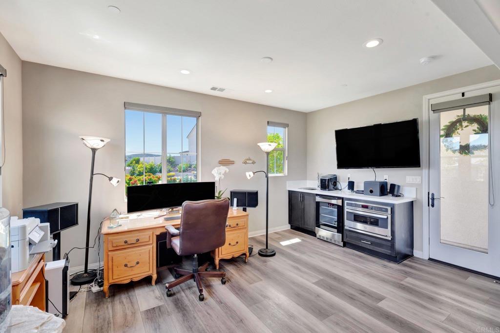 22005 Long Trot Drive Escondido, CA 92029 - Photo 27 of 51 a view of a workspace with furniture and a flat screen tv