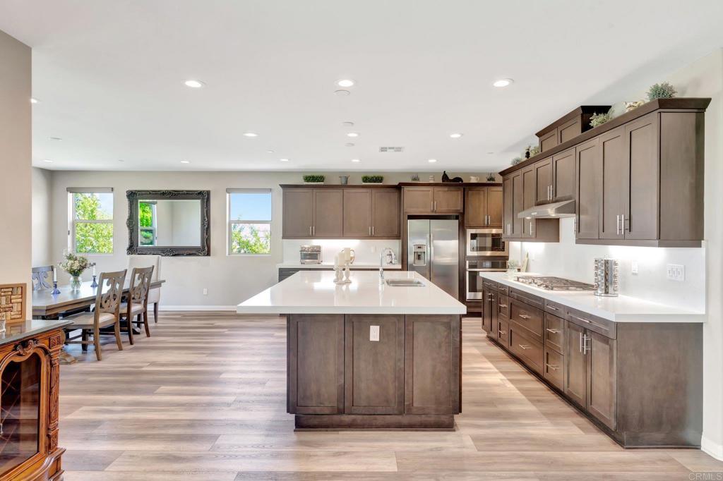 22005 Long Trot Drive Escondido, CA 92029 - Photo 7 of 51 a kitchen with stainless steel appliances kitchen island granite countertop a kitchen island a stove a sink a dining table and chairs
