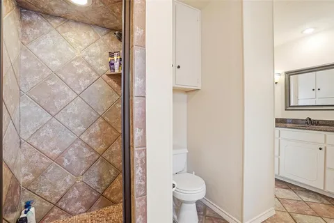 a bathroom with a granite countertop sink toilet and shower