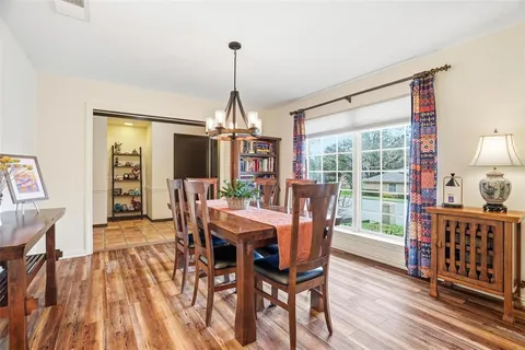 a view of a dining room with furniture a chandelier and wooden floor