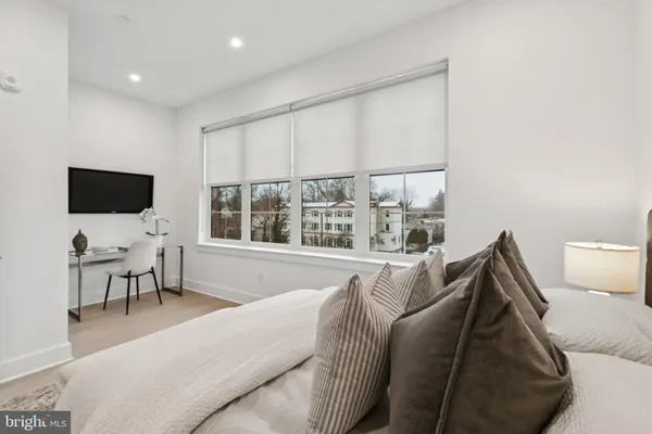 a living room with furniture a flat screen tv and a large window