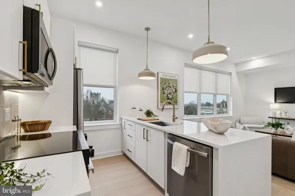a kitchen with stainless steel appliances granite countertop a sink a stove and a wooden floors