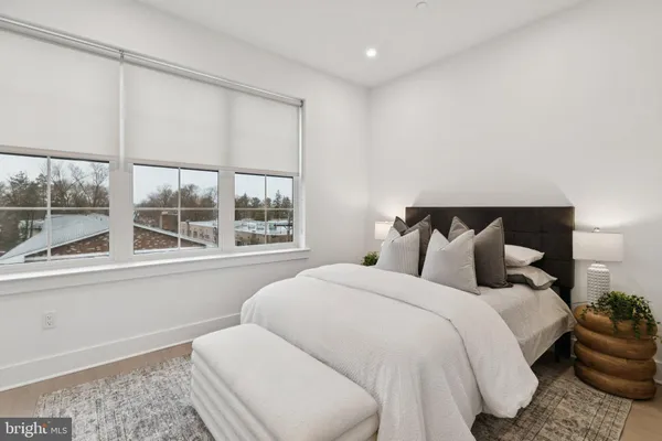 a bedroom with bed and a large window