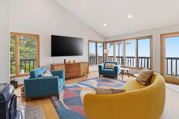 a dining room with furniture large windows and wooden floor