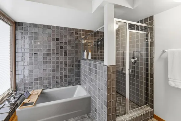 a bedroom with a bed and large windows