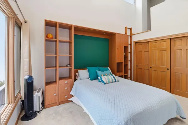 a bedroom with a bed and a large window