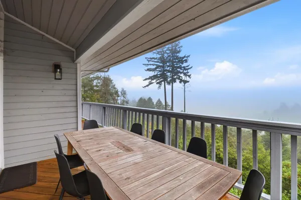 a balcony with wooden floor table and chairs