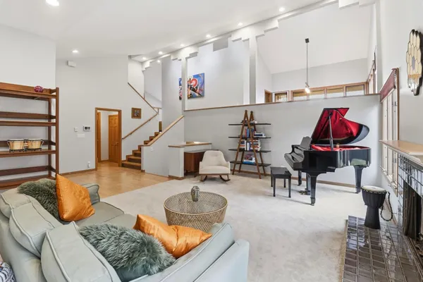 a living room with furniture a rug a fireplace and a large window